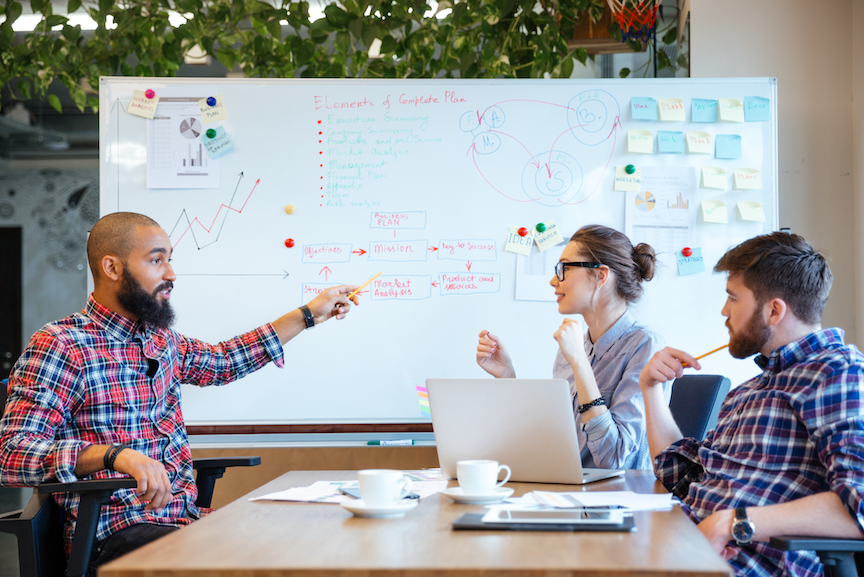 Group meeting in front of a white board